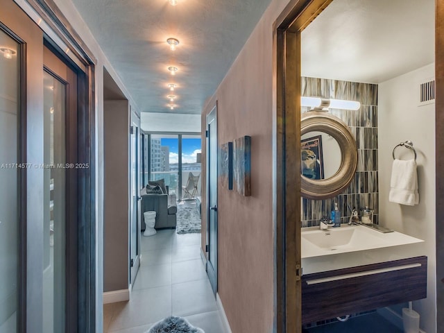 hallway with light tile patterned flooring and sink