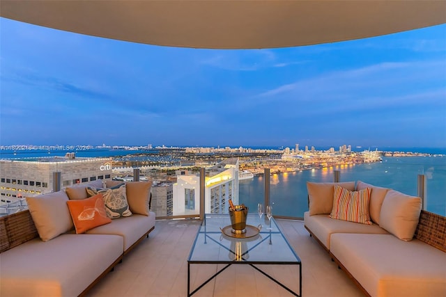 balcony with an outdoor living space, a water view, and a patio