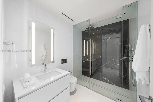 bathroom featuring vanity, toilet, a shower with door, and tile walls