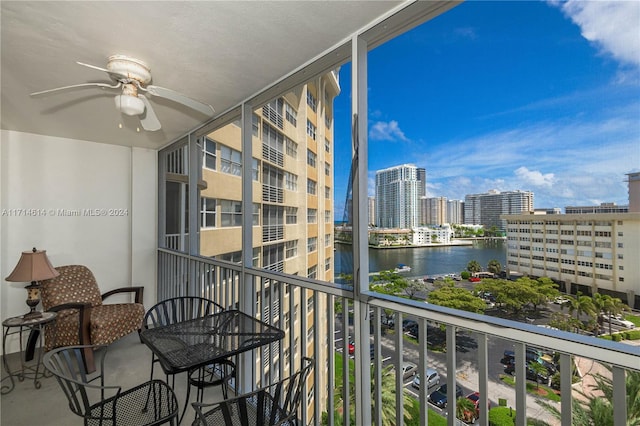 balcony with a water view and ceiling fan