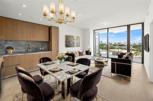 dining space with expansive windows, sink, and a chandelier