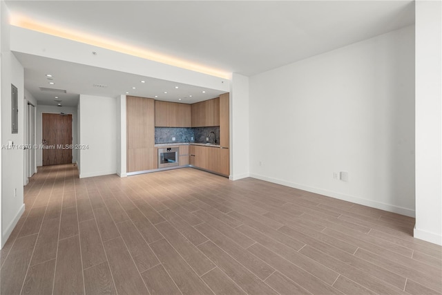 unfurnished living room featuring light hardwood / wood-style floors and sink