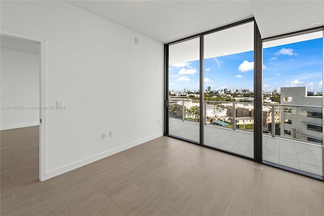 unfurnished room featuring hardwood / wood-style floors and expansive windows