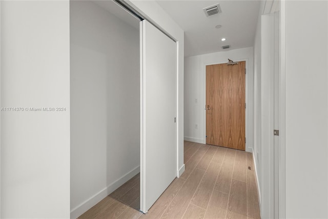 corridor with light hardwood / wood-style flooring