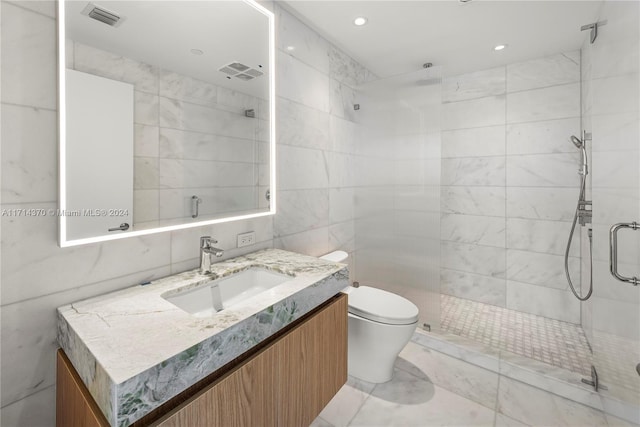 bathroom featuring vanity, toilet, a shower with shower door, and tile walls