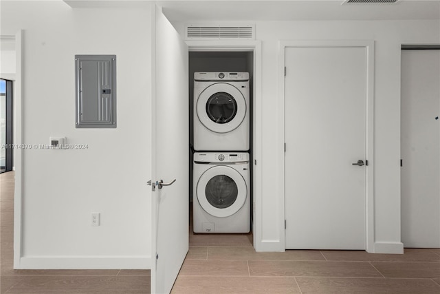 washroom with electric panel and stacked washer and clothes dryer