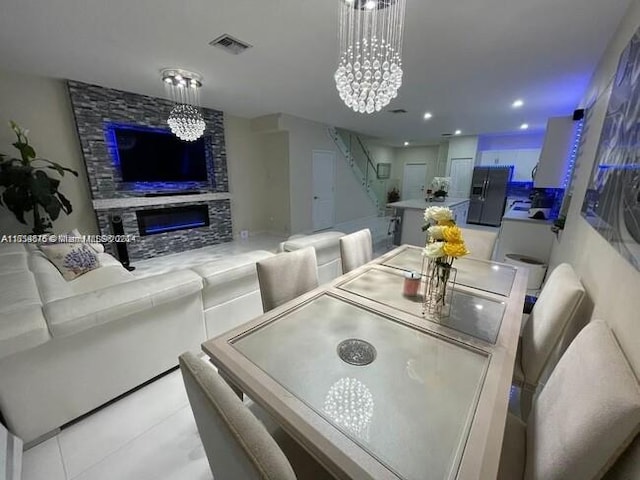 dining area featuring a chandelier and a stone fireplace