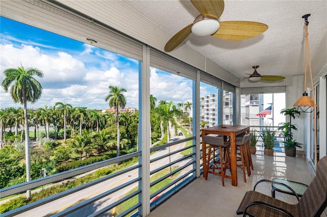 sunroom / solarium featuring ceiling fan