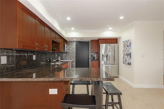 kitchen featuring kitchen peninsula, a kitchen breakfast bar, backsplash, stainless steel appliances, and sink