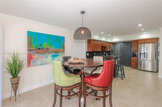 tiled dining area featuring ornamental molding and sink