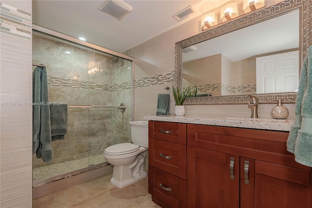 bathroom featuring tile patterned floors, vanity, toilet, and walk in shower