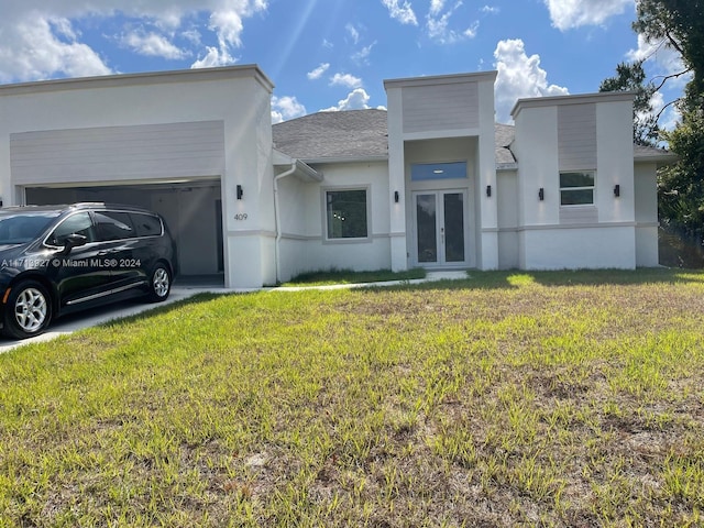 view of front of house with a garage, french doors, and a front lawn