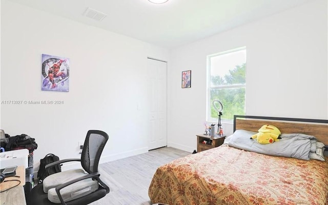 bedroom with light hardwood / wood-style flooring and a closet