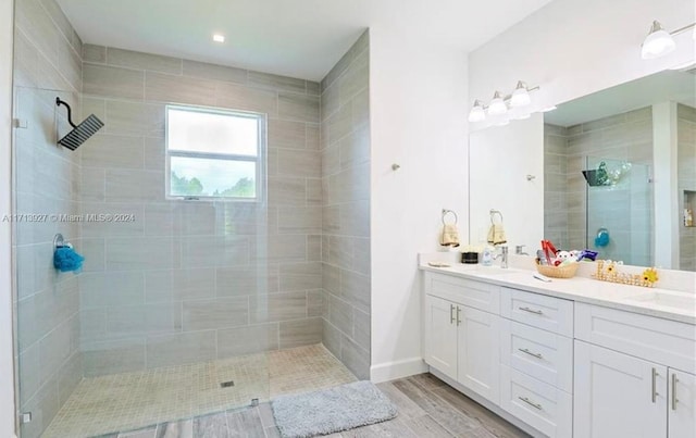 bathroom with tiled shower and vanity