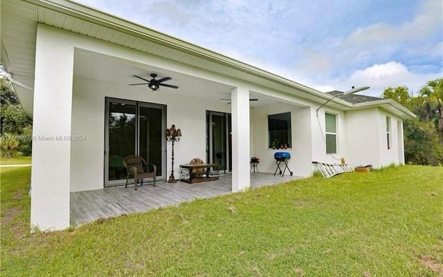 rear view of property with a lawn, ceiling fan, and a patio