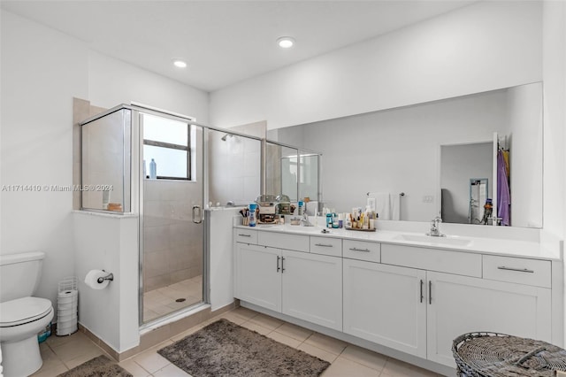 bathroom with tile patterned flooring, vanity, toilet, and a shower with door