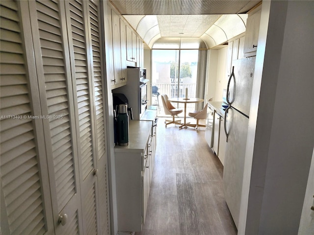 hall featuring floor to ceiling windows and light wood-style floors