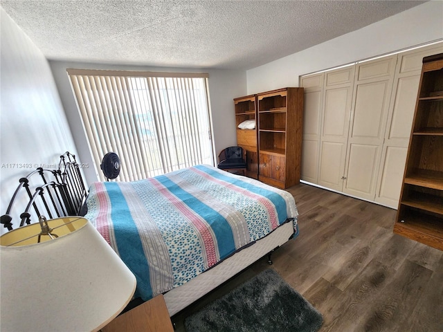 bedroom featuring a closet, a textured ceiling, and dark wood-type flooring