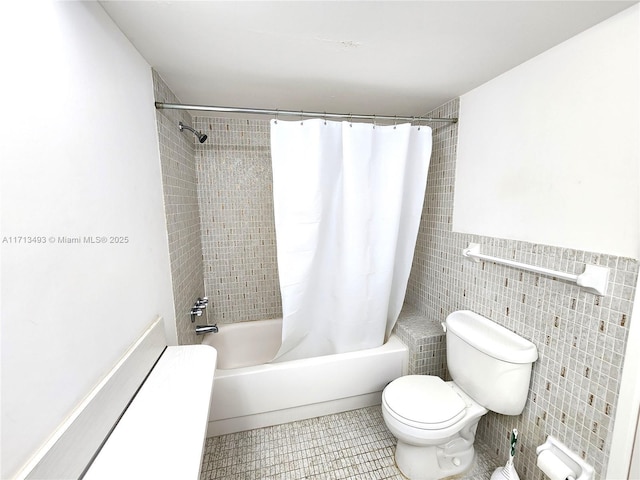 full bathroom with toilet, shower / bath combination with curtain, tile walls, and tile patterned floors