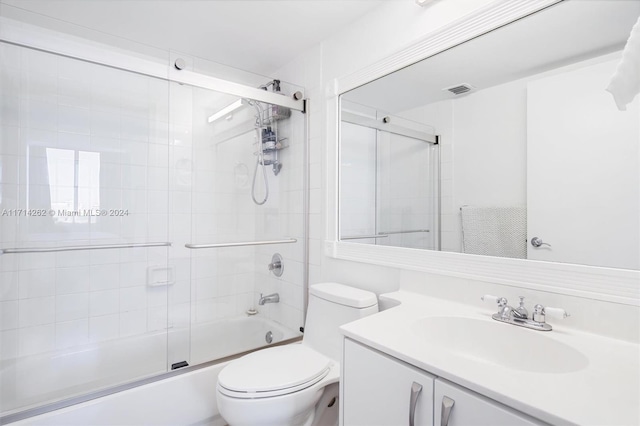 full bathroom with combined bath / shower with glass door, vanity, and toilet