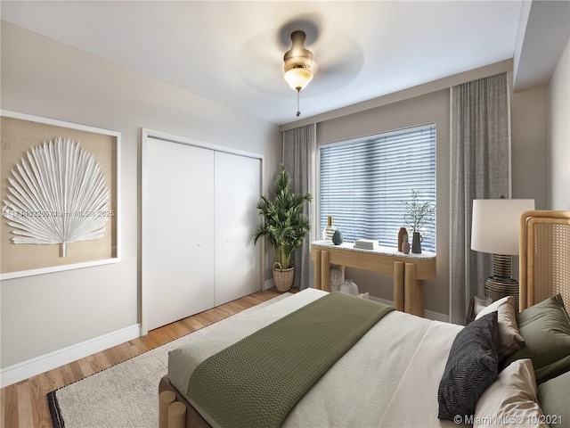 bedroom with ceiling fan, a closet, and hardwood / wood-style floors