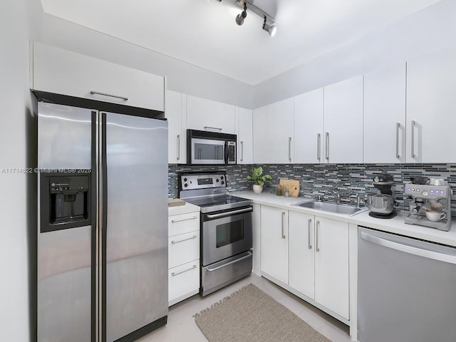 1018 Meridian Ave Unit 4, Miami Beach, FL 33139 - kitchen featuring appliances with stainless steel finishes, light countertops, decorative backsplash, white cabinetry, and light tile patterned floors
