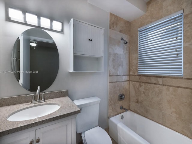 full bathroom with tiled shower / bath combo, vanity, and toilet