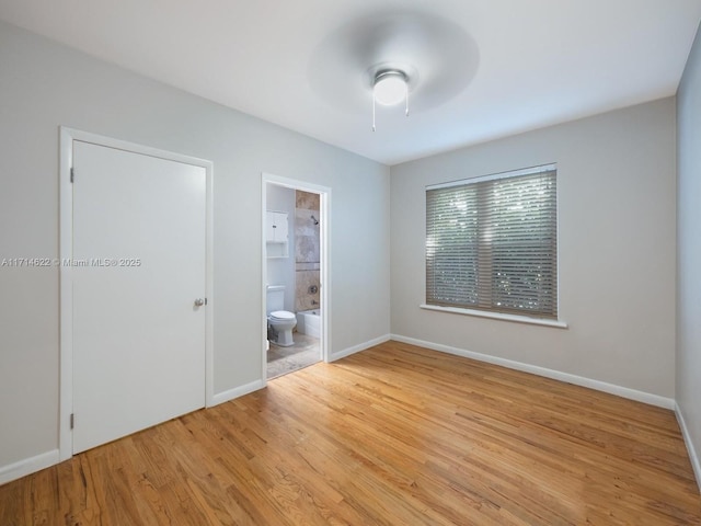 1018 Meridian Ave Unit 4, Miami Beach, FL 33139 - unfurnished bedroom featuring light wood finished floors, baseboards, ensuite bath, and ceiling fan