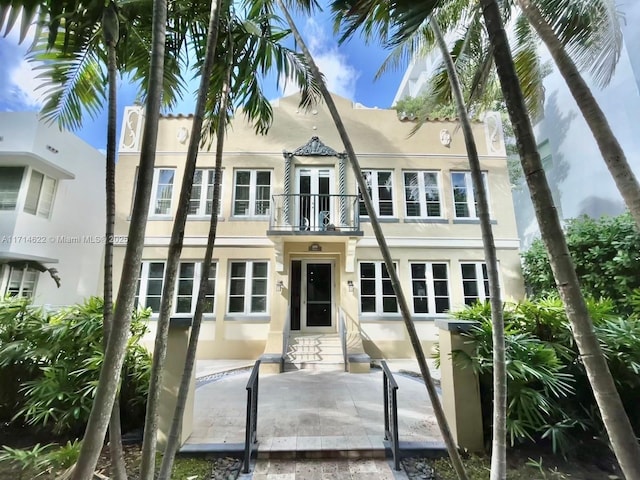 1018 Meridian Ave Unit 4, Miami Beach, FL 33139 - view of front of house with a balcony, stucco siding, entry steps, and a patio area