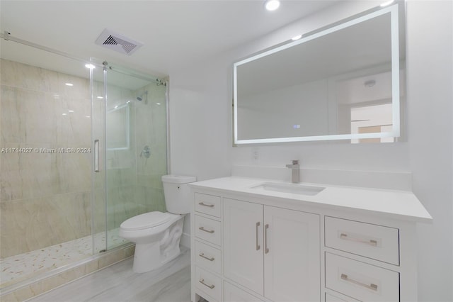 bathroom with vanity, an enclosed shower, and toilet