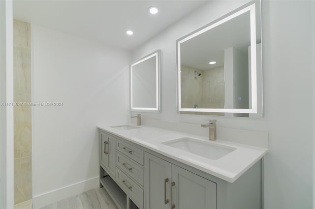 bathroom featuring vanity, a shower, and wood-type flooring