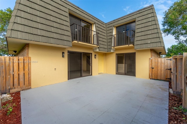 rear view of property with a balcony and a patio