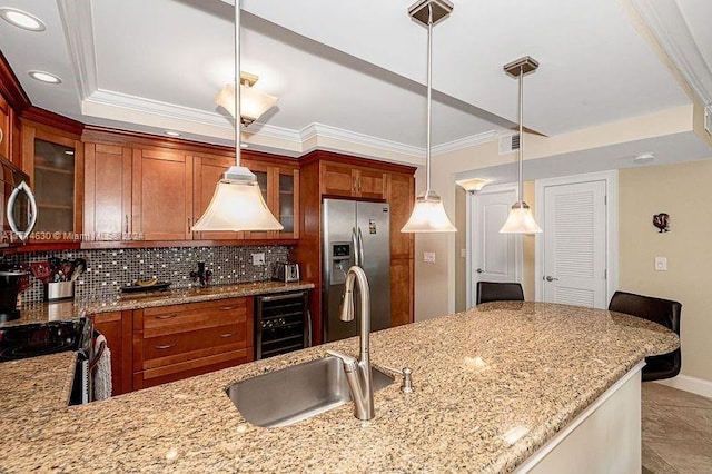 kitchen with light stone countertops, sink, backsplash, pendant lighting, and appliances with stainless steel finishes