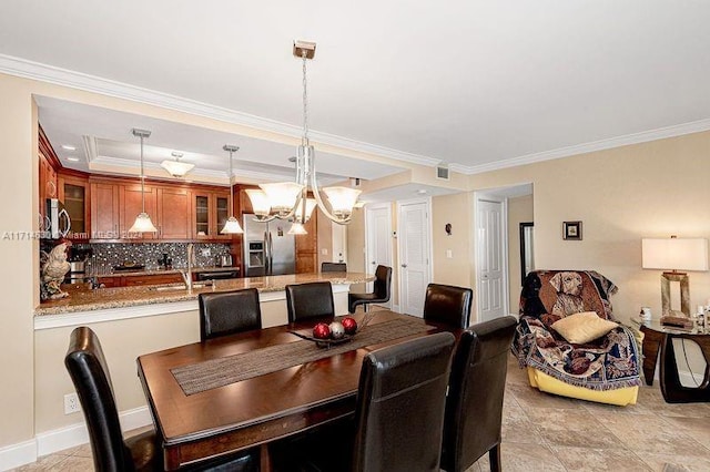 dining space featuring sink, crown molding, and a notable chandelier