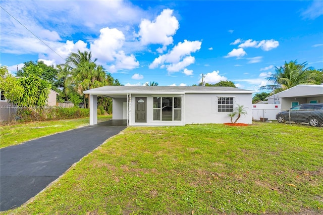 view of front of property featuring a front lawn and a carport