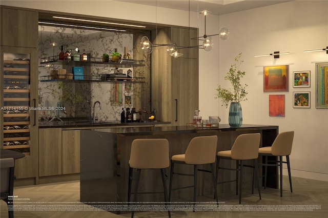 bar featuring decorative backsplash, sink, decorative light fixtures, and parquet flooring