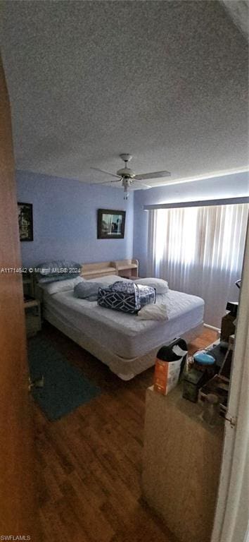 bedroom featuring a textured ceiling, hardwood / wood-style flooring, and ceiling fan