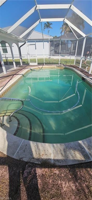 view of pool featuring glass enclosure