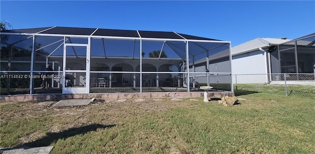 rear view of house featuring a lanai and a yard