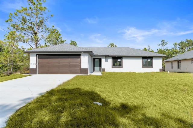 view of front facade with an attached garage, concrete driveway, a front lawn, and stucco siding