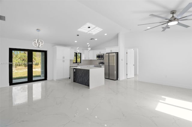 kitchen with stainless steel appliances, a kitchen island, vaulted ceiling, white cabinets, and recessed lighting