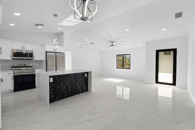 kitchen with appliances with stainless steel finishes, ceiling fan with notable chandelier, white cabinets, a center island, and hanging light fixtures