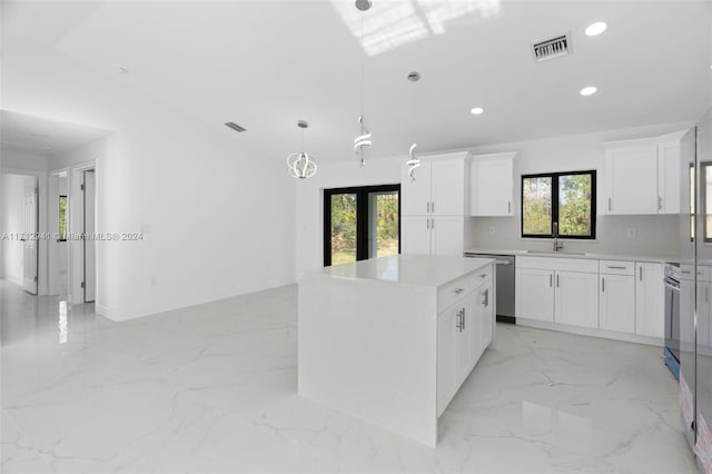 kitchen with french doors, stainless steel dishwasher, white cabinets, a kitchen island, and hanging light fixtures