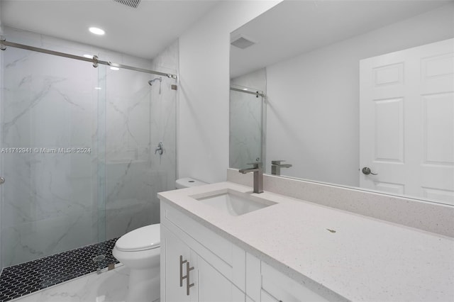 bathroom featuring toilet, a marble finish shower, marble finish floors, vanity, and recessed lighting