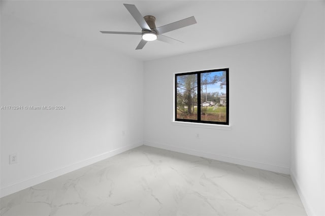 unfurnished room featuring baseboards, light marble finish flooring, and ceiling fan