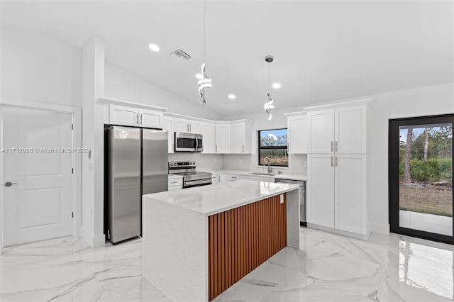 kitchen with decorative light fixtures, a center island, stainless steel appliances, and white cabinetry