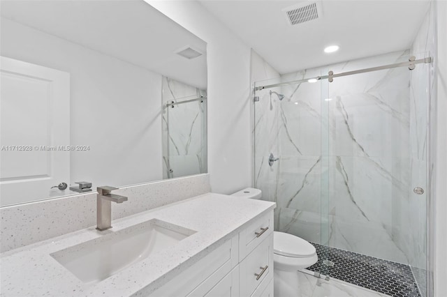 bathroom with vanity, toilet, and a shower with door