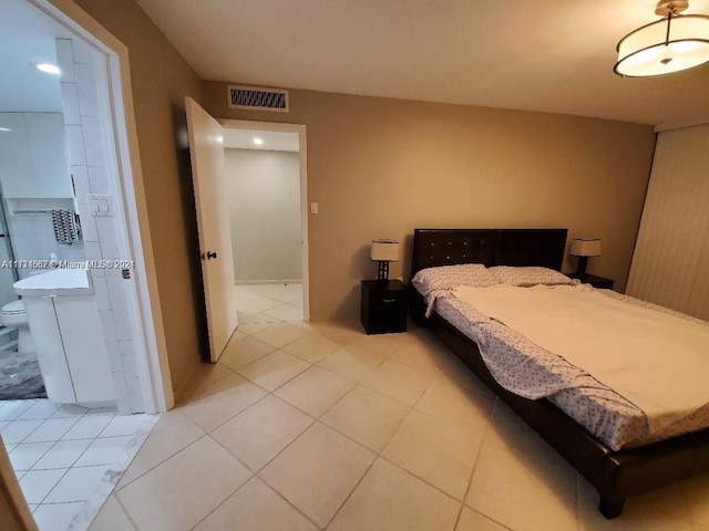 tiled bedroom featuring ensuite bath