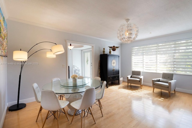 dining room featuring ornamental molding and light wood-type flooring