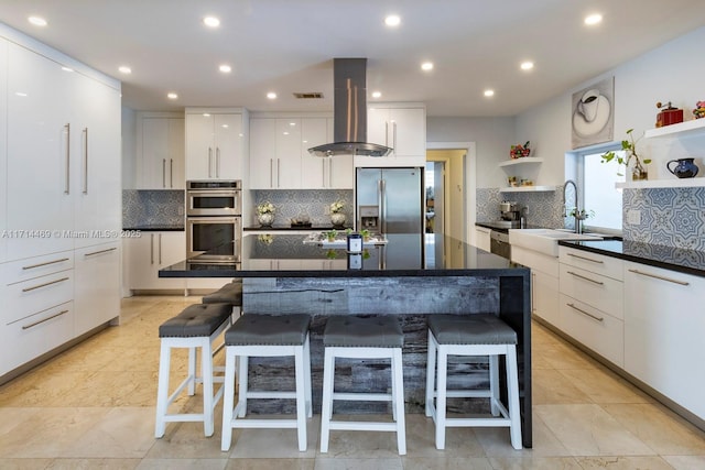 kitchen with white cabinetry, tasteful backsplash, island range hood, a center island, and stainless steel appliances